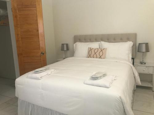 Newcastle VillageCompassionate Touch Spa的卧室配有带毛巾的大型白色床