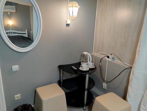 下诺夫哥罗德安养之家酒店的浴室设有镜子、桌子和2把凳子
