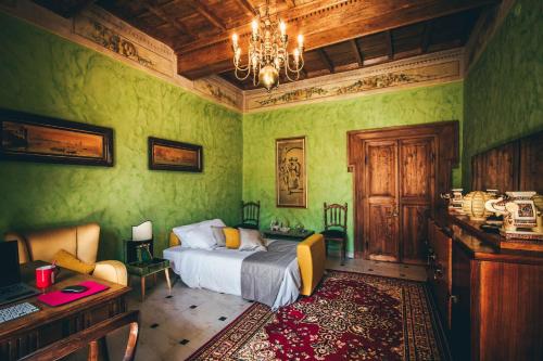 奥尔泰ART DÉCO 1920 Vicino AUTOSTRADA 40 MIN ROMA的一间卧室设有绿色的墙壁、一张床和一个吊灯。