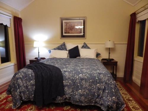AshbourneThe Retreat at Amryhouse的一间卧室配有一张带蓝色棉被的床