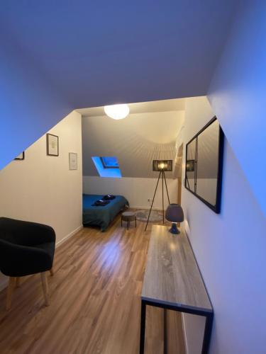 万泽内姆Duplex moderne à 10 minutes de Colmar的客房设有床、桌子和蓝色天花板。