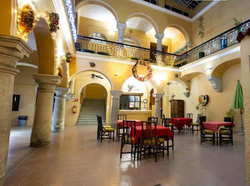 瓦哈卡市Hotel Nueva Antequera的大楼内带桌椅的大型客房
