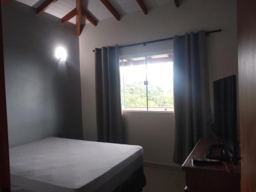 伊利亚贝拉Chalé Boa Vista的一间卧室设有一张床和一个窗口