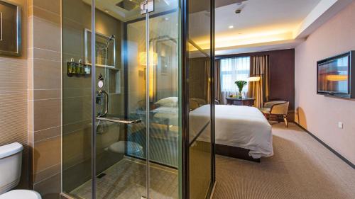杭州杭州东站汇和君亭酒店的带淋浴的浴室和客房内的一张床