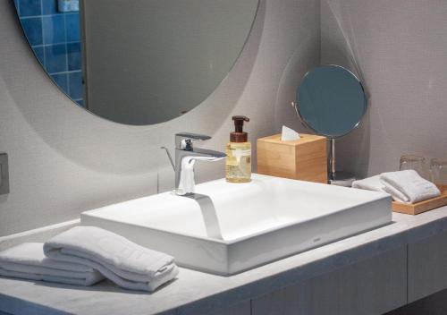 头城凯渡广场温泉酒店的浴室设有白色水槽和镜子