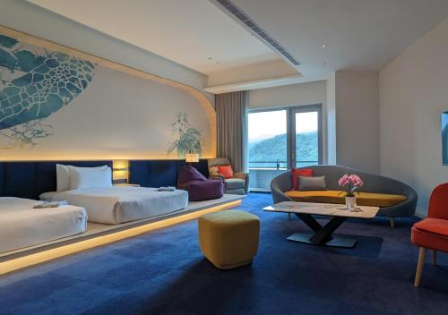 头城凯渡广场温泉酒店的酒店客房,配有床和沙发