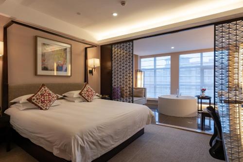 杭州杭州东站汇和君亭酒店的一间卧室设有一张大床和一个浴缸
