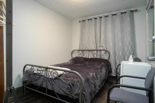 渥太华Room #4 Ottawa downtown的一间卧室配有带窗帘的金属床