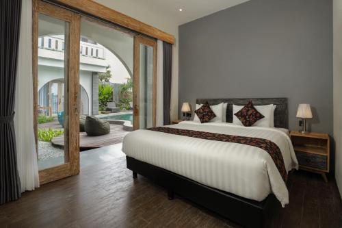 坎古MAHALONA BALI STAY的一间卧室设有一张大床和一个大镜子