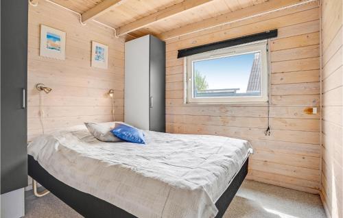 猎枪海滩候姆莱维耶五号度假屋的卧室配有木墙内的一张床