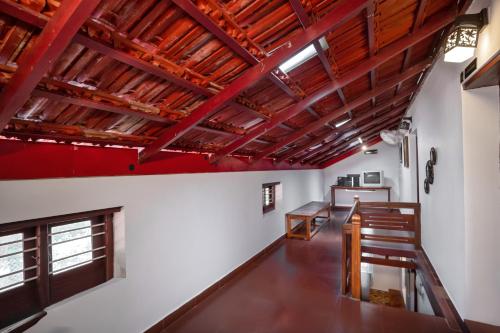 LakkidiAnamala Serenity Homestay Kerala的客房拥有红色的天花板和木梁。