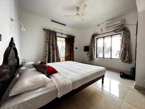特里凡得琅Kovalam Beach House的一间卧室配有一张大床和吊扇