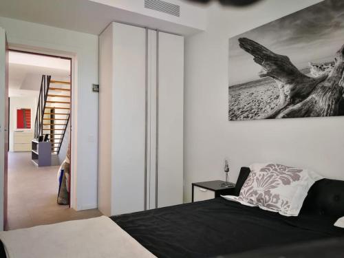 马略卡岛帕尔马Precioso chalet vanguardista的卧室配有一张床,墙上挂有绘画作品