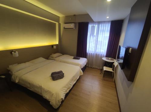 斯里巴加湾市EZ Suites的酒店客房设有两张床和电视。