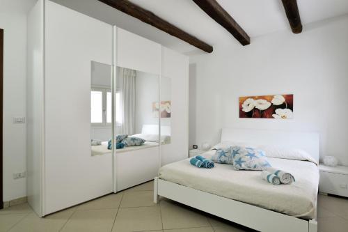 LoceriCasa Vacanza Il Murales的白色卧室配有床和镜子