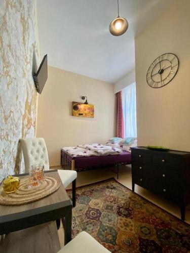 格武霍瓦济Butikowe Pokoje Zdrój Głuchołazy的一间卧室配有一张床、一张桌子和闹钟