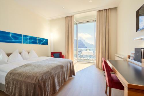 布鲁嫩沃尔德斯塔得霍夫瑞士品质酒店的配有一张床、一张书桌和一扇窗户的酒店客房