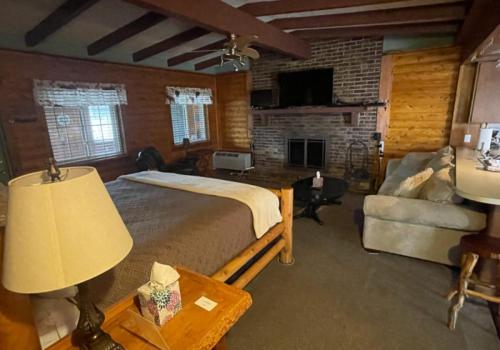 ClarkstonOlde Mill Inn of Clarkston的一间卧室配有一张床、一张沙发和一张桌子