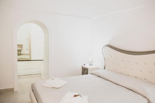 马泰拉Acasadifelice的白色卧室配有带2条毛巾的床