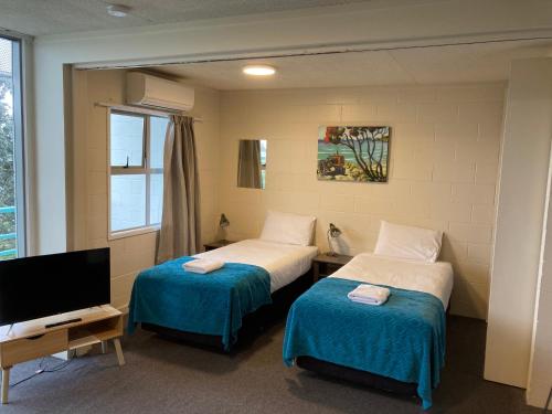 奥克兰City Towers Apartments的酒店客房设有两张床和电视。