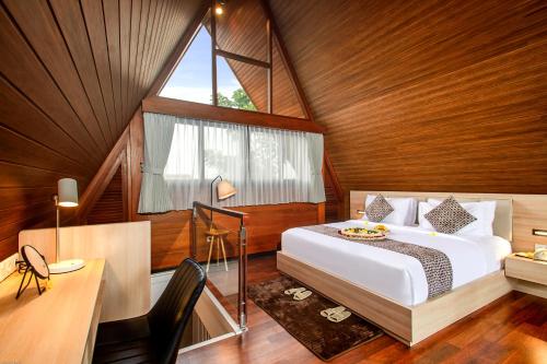 乌布Kanhara Villas Ubud by Pramana Villas的一间卧室配有一张床、一张书桌和一个窗户。
