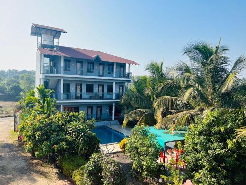 阿利鲍格iIRA Stays-Awas Beach Resort - Pet Friendly的一座带游泳池和棕榈树的房子