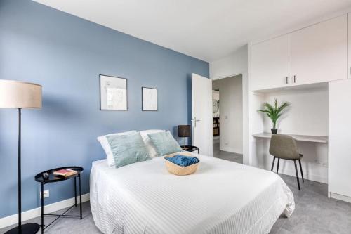 圣但尼Premium Flat 6 People with billard and Terrace Stade de France的卧室配有白色的床和蓝色的墙壁