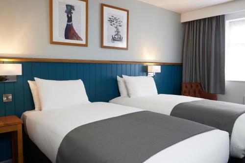 黑多克The Bay Horse Hotel的两张位于酒店客房的床,拥有蓝色的墙壁