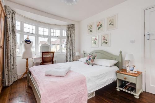牛津Orchard - 3 Bedroom House Headington & parking & garden的一间卧室配有一张床、一把椅子和窗户。