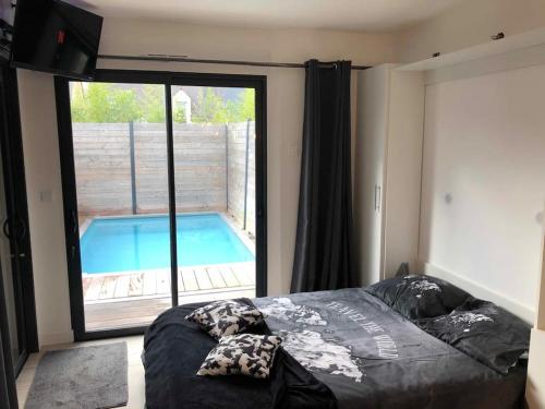 布吕兹Loft privatisé avec spa XXL et piscine chauffée的一间卧室设有一张床和一个游泳池