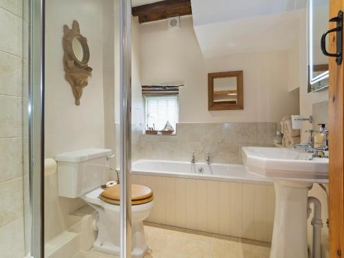 DaglingworthFlowers Barn的浴室配有卫生间、盥洗盆和浴缸。