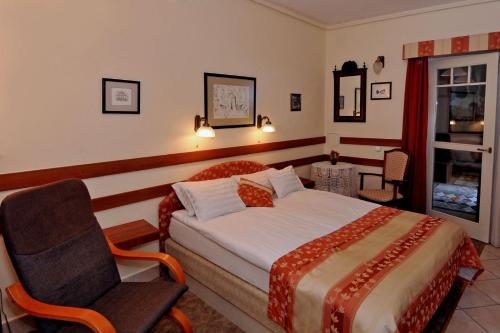 埃格尔Pátria Panzió的配有一张床和一把椅子的酒店客房