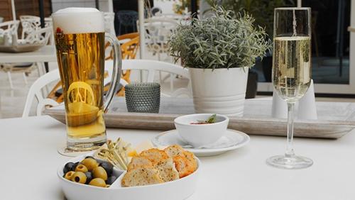 德累斯顿德累斯顿诺瓦利斯酒店的一张桌子,上面放着一盘食物和一杯啤酒