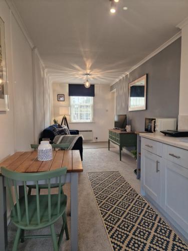 卡比斯贝Small Cottage close to Carbis Bay Beach & St Ives的厨房以及带桌子和沙发的客厅。