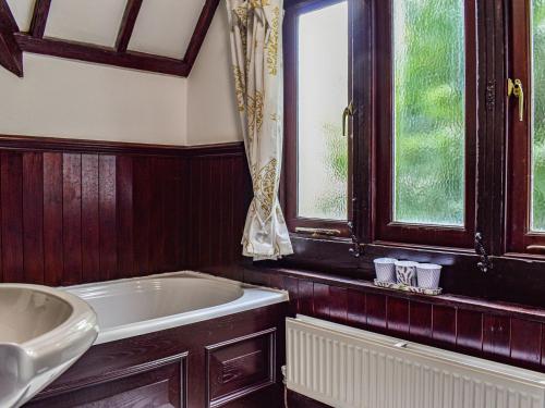 拉尔Heritage Lodge的带浴缸的浴室和窗户。