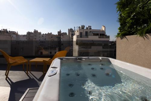 雅典LUX&EASY Athens Metro Suites的市景阳台的热水浴池