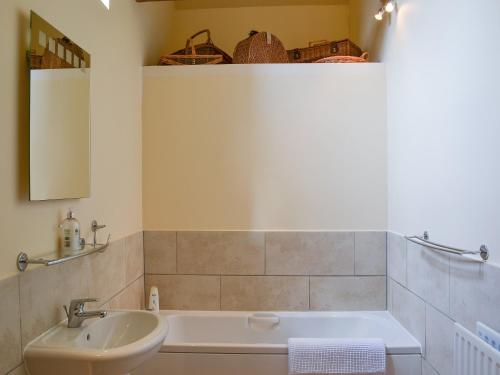 binbrookBinbrook House Mews的浴室配有盥洗盆和浴缸。
