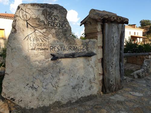 Olmeda de CobetaCasa Rural don Rosendo的石墙边的标志