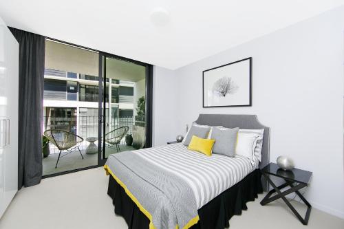 堪培拉CityStyle Apartments - BELCONNEN的一间白色卧室,配有床和阳台