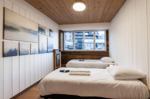布里昂松Appartement Europa的带2扇窗户的客房内的2张床