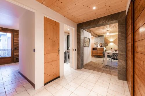 布里昂松Appartement Europa的走廊设有木门和用餐室
