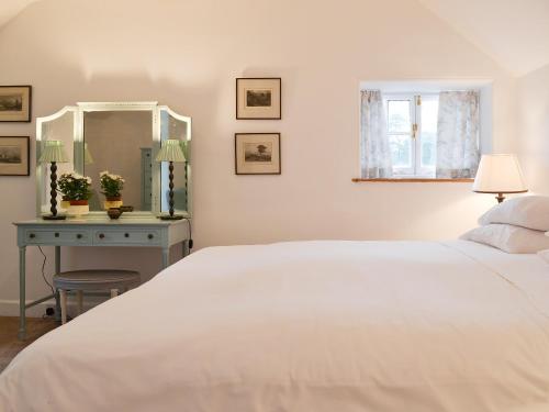 Strachur花园度假屋的卧室配有白色的床和蓝色的桌子