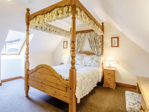 Runcton HolmeArchway Barn - E3864的一间卧室配有一张木制四柱床