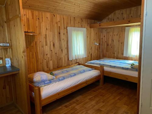 SepeneKurzemes pērle的小木屋内一间卧室,配有两张床