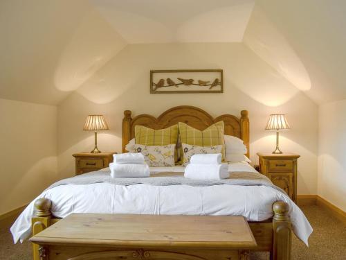 肯莫尔Deuchars Cottage的一间卧室配有一张大床和两盏灯