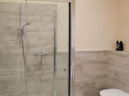 binbrookGranary Lodge的浴室里设有玻璃门淋浴