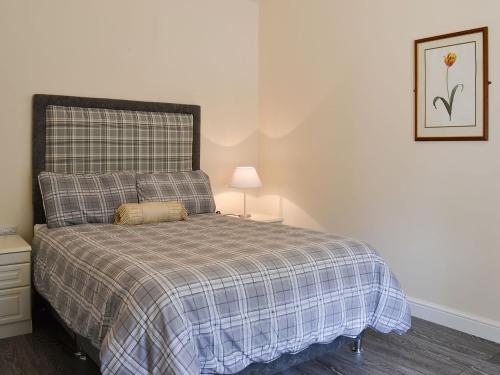 binbrookGranary Lodge的一间卧室配有一张带铺着平底毯的床