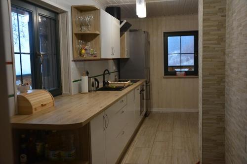 卡缅纳古拉Pod Zielonym Dachem的厨房配有白色橱柜和木制台面