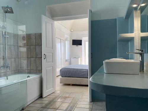 易莫洛林Alexander Villas的一间带水槽和浴缸的浴室以及一张床