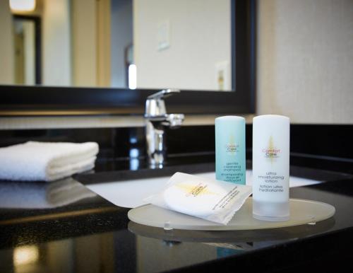 七岛市七岛港康福特茵酒店的浴室柜台,配有2条毛巾和2种产品